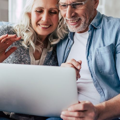 An older couple using a computer, possibly managing financial or home-related matters.