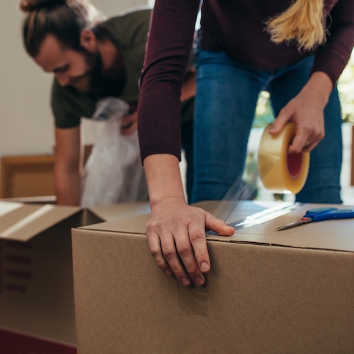 Couple packing up boxes to move.