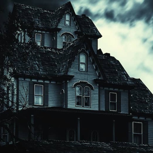 Creepy haunted house with dark windows and overgrown yard.