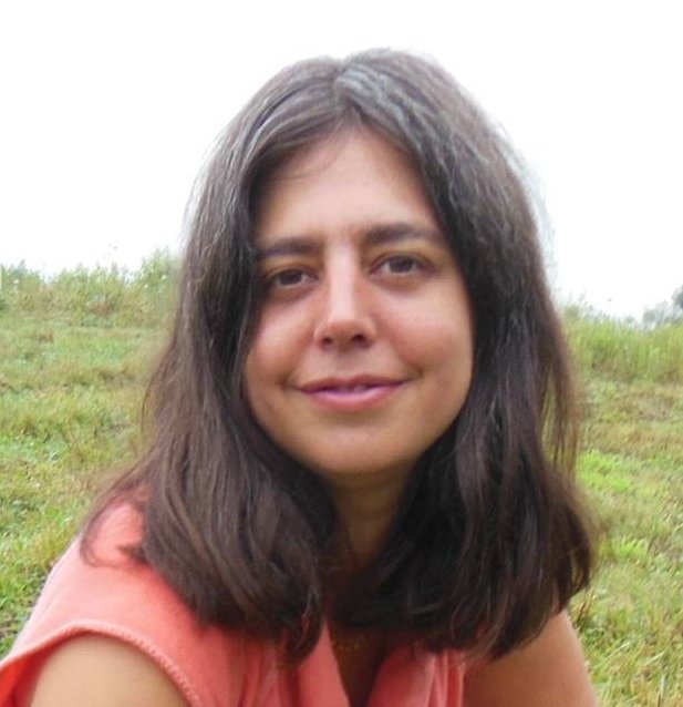 Headshot of Sarah Lozanova, with grass and grey sky in the background.