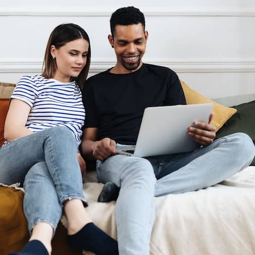 A couple looking at a laptop together, possibly discussing or working on something collaboratively.