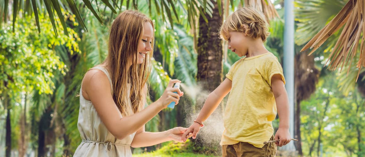 RHB Assets From IGX: Woman applying mosquito repellent on her arm outdoors