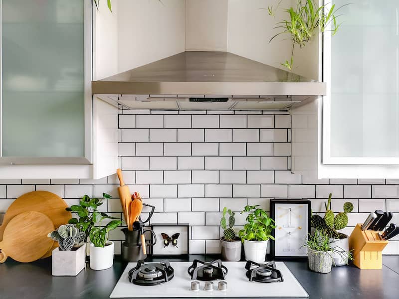 White subway tile backsplash above stove and countertops.