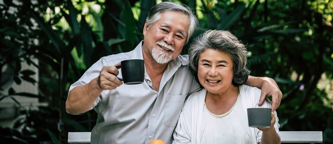 An older couple drinking tea in a garden, potentially illustrating a tranquil retirement or leisure setting.