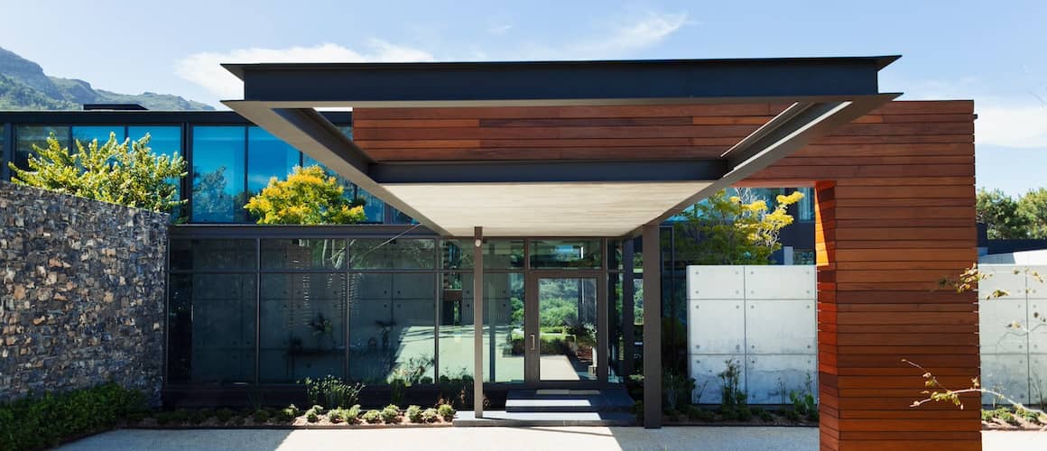 Contemporary home with wood panelled exterior and glass floor to ceiling windows.