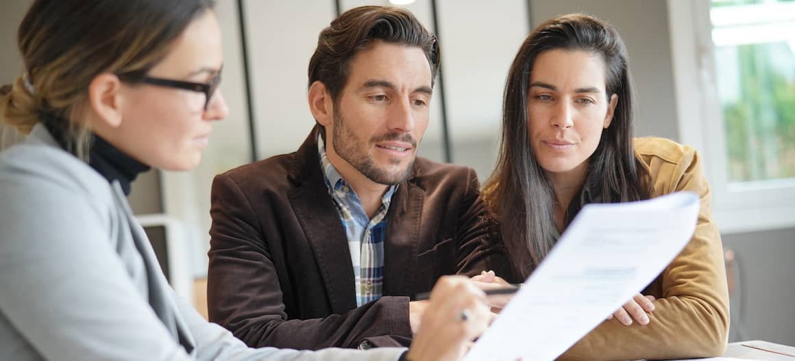 A couple discussing terms and condition possible for mortgage or related to real estate with an agent.