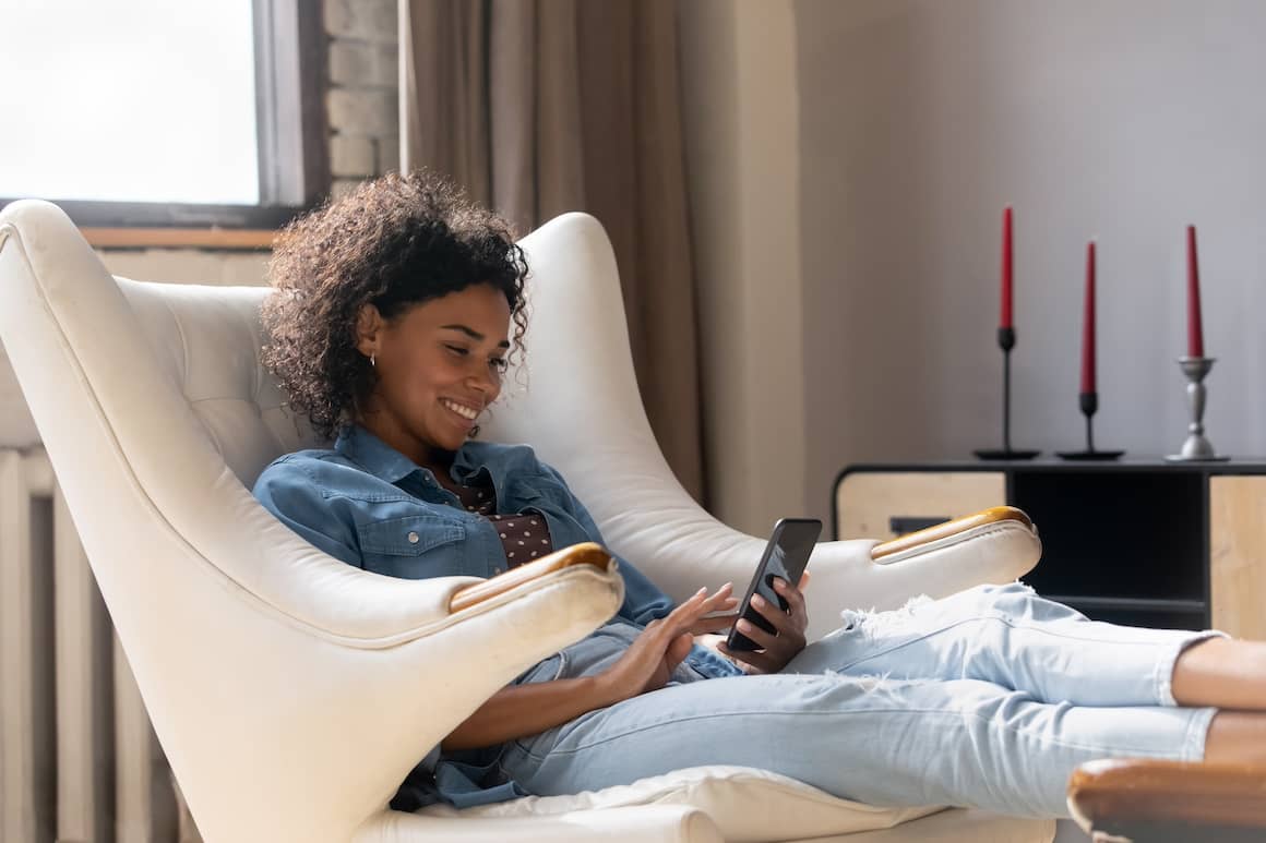 Woman on couch looking at phone.