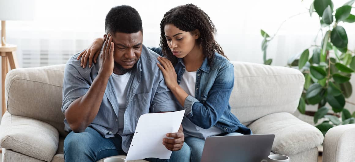 Image indicating a worried couple possibly by taxes or some other information written on the paper.
