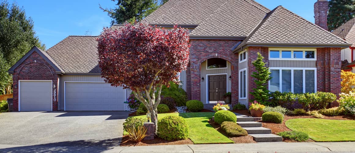 A large brick home with a landscaped front yard, highlighting curb appeal and home aesthetics.