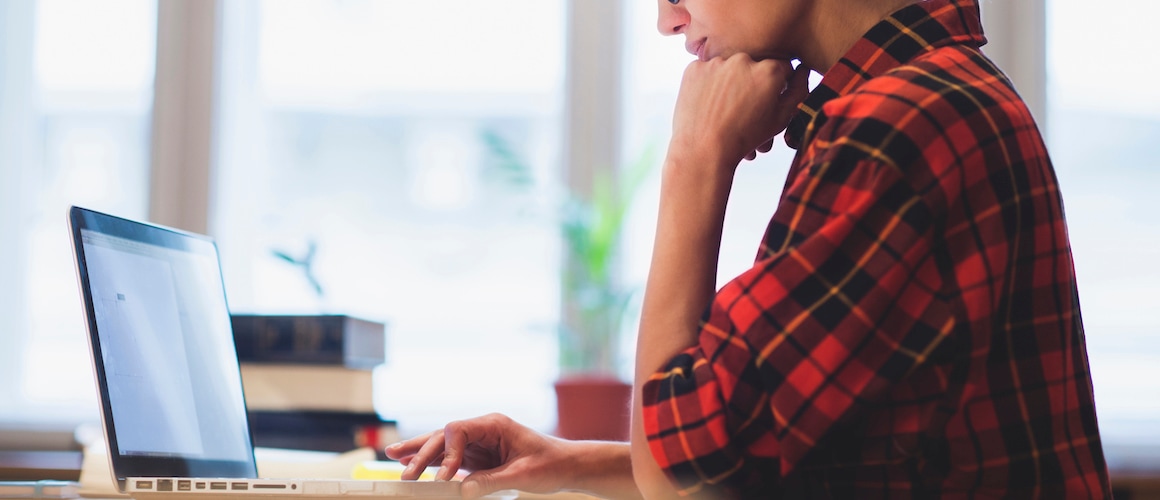 Woman working on a computer, possibly managing real estate details or financial matters.