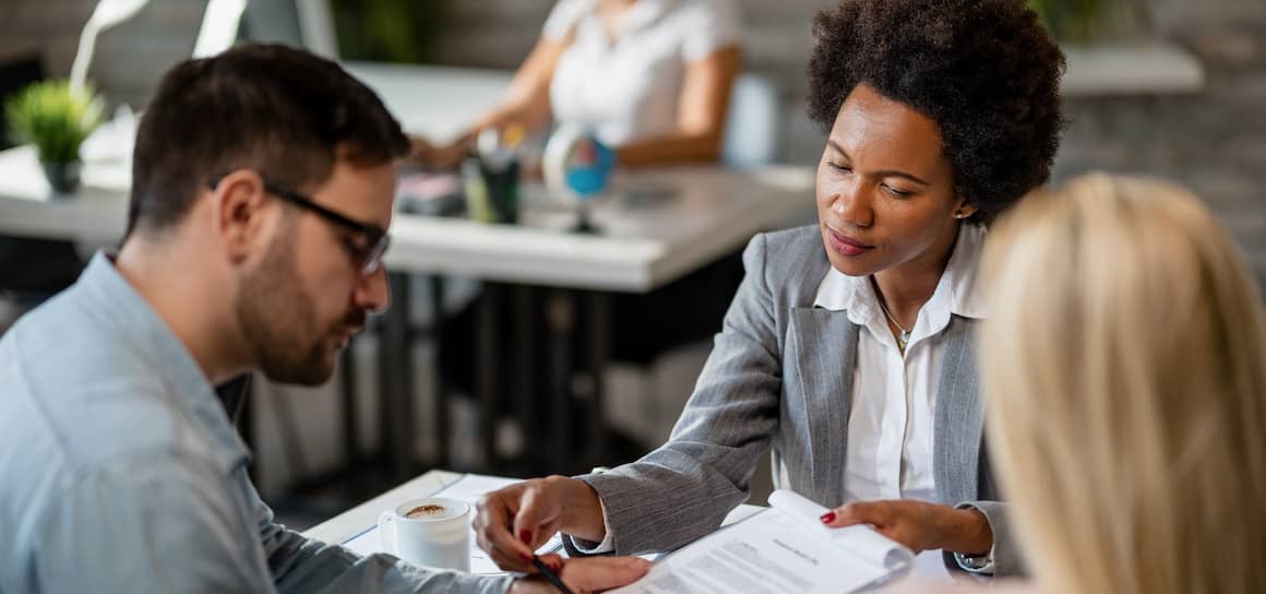 A couple talking over a contract with a lawyer.