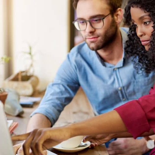 A couple pointing at a laptop, suggesting discussions or decisions related to real estate or finances.