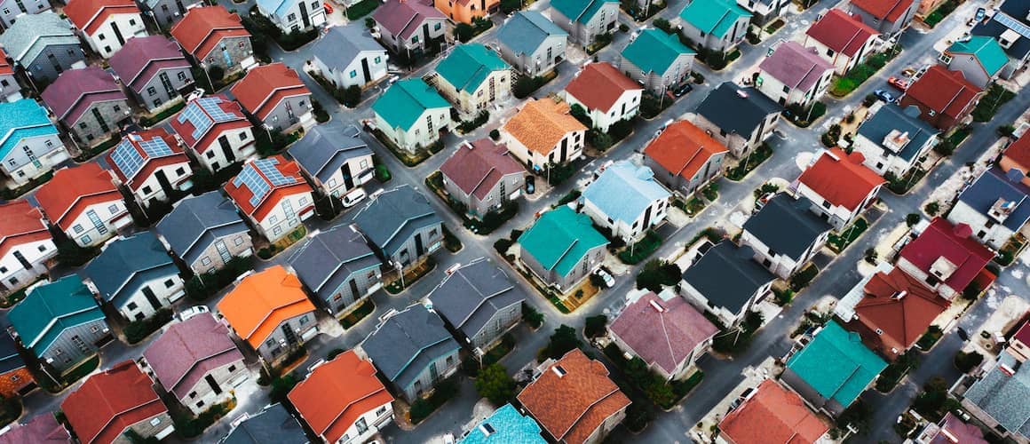 Aerial view of vibrant and colorful neighborhood, showcasing diverse houses and surroundings.