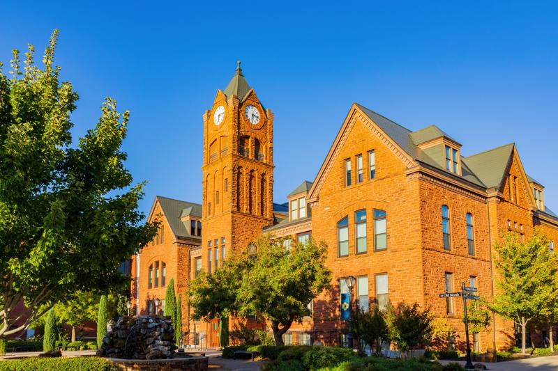 Old North Tower of the University of Central Oklahoma brightly lit by the setting sun.