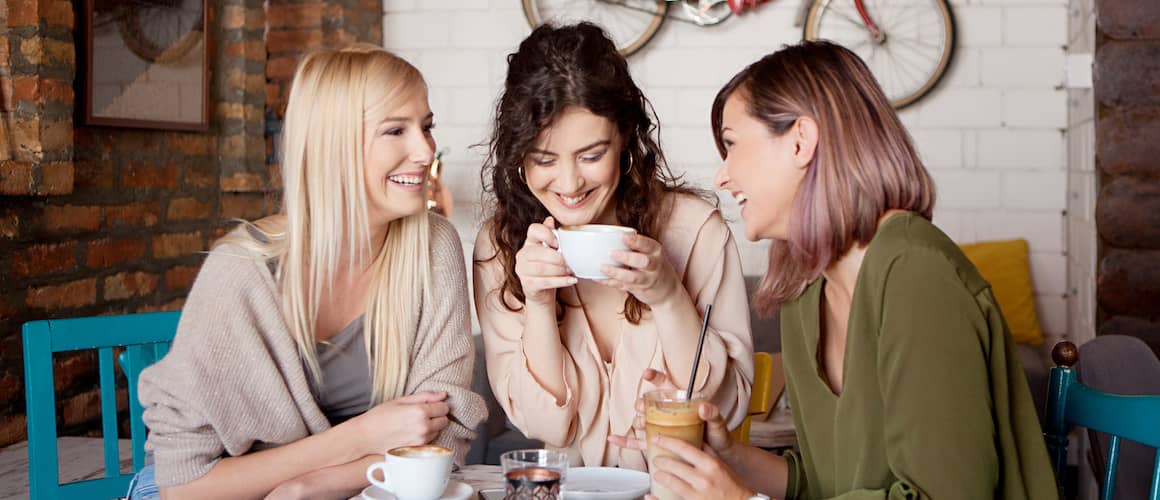 Three women having coffee together in a cafe.