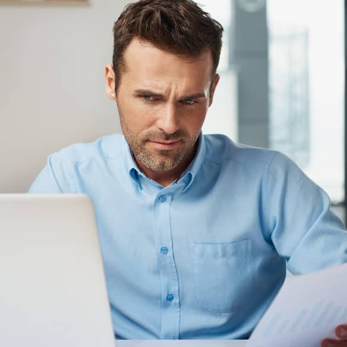 A man working on paperwork, potentially related to mortgage documents or financial planning.