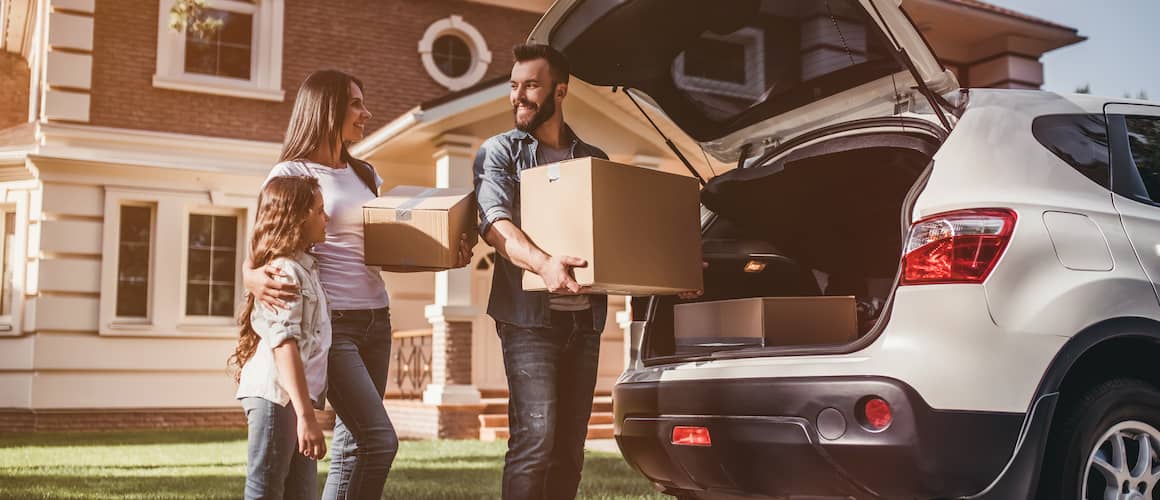 A family packing a car to move, indicating a relocation or moving process.