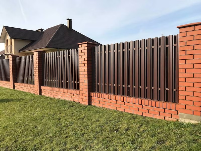 Metal and brick fence outside house.