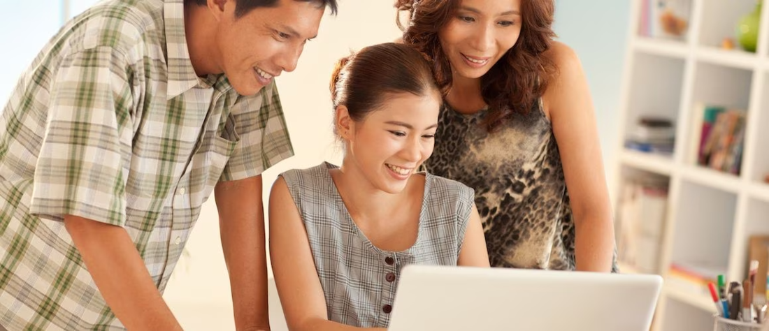 Asian family looking at a laptop together.