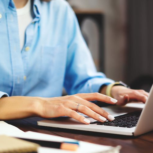 A woman working on a computer at home, potentially related to online mortgage or real estate activities.
