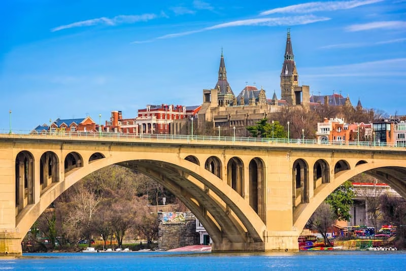 View of bridge over water in foreground with city in background