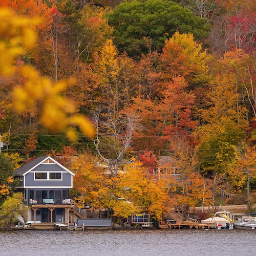 Lakehouse in northern New Hampshire against backdrop of fall foliage.