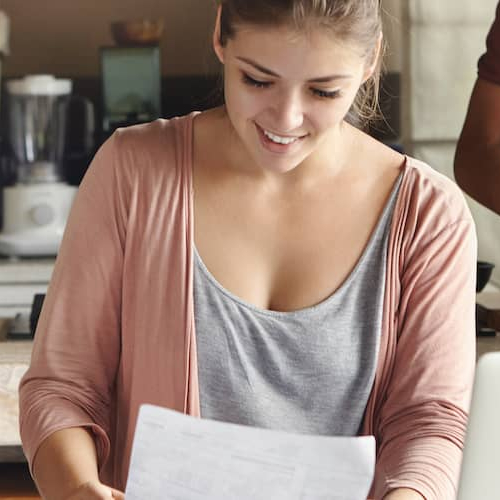 Woman reviewing pay stubs and finances, illustrating a woman examining pay stubs and financial documents, likely related to mortgage or financial planning.