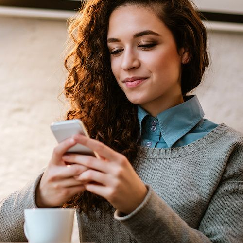 A woman working on a laptop, possibly related to real estate research or home-related tasks.