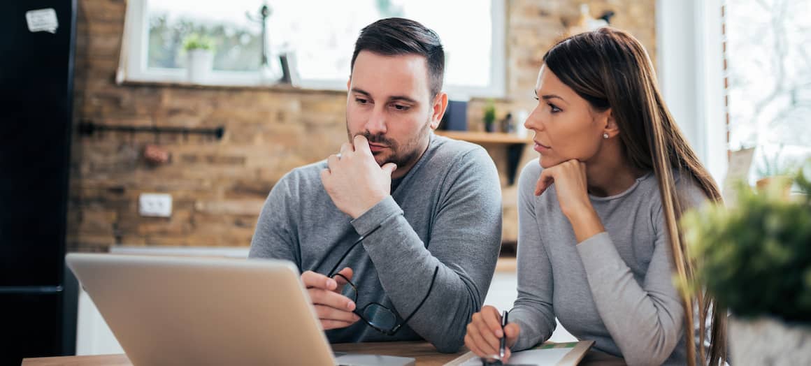 A couple analyzing mortgage rates, possibly comparing options for home financing.