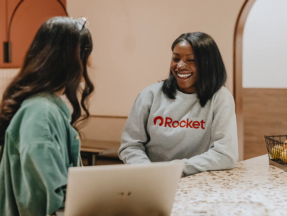 Two team members enjoying a conversation together while working.