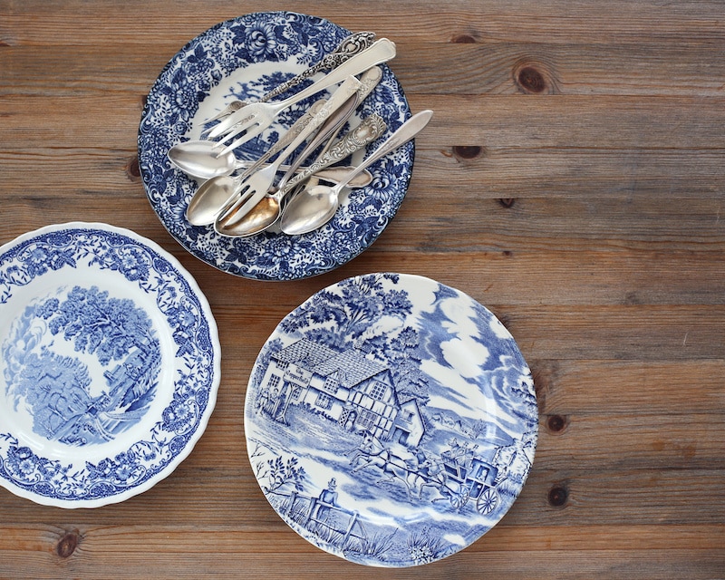 RHB Assets From IGX: Vintage china set with ornate patterns on a wooden table.