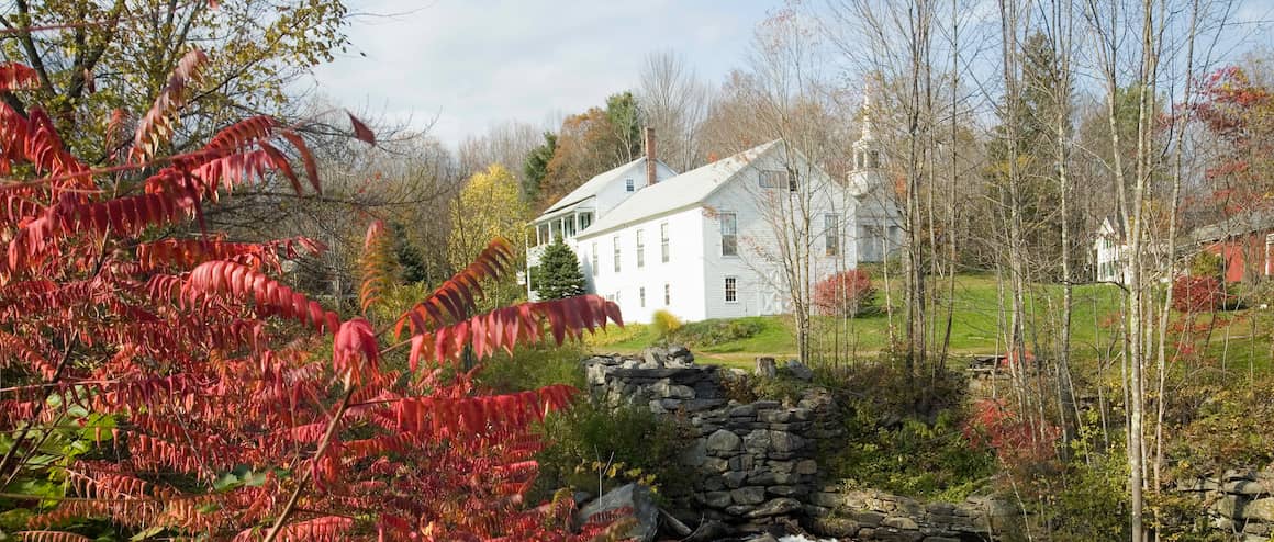 Colonial-style house in Massachusetts with a white exterior and greenery.