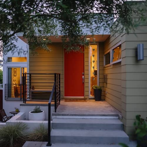 Sage green house with burnt orange door.