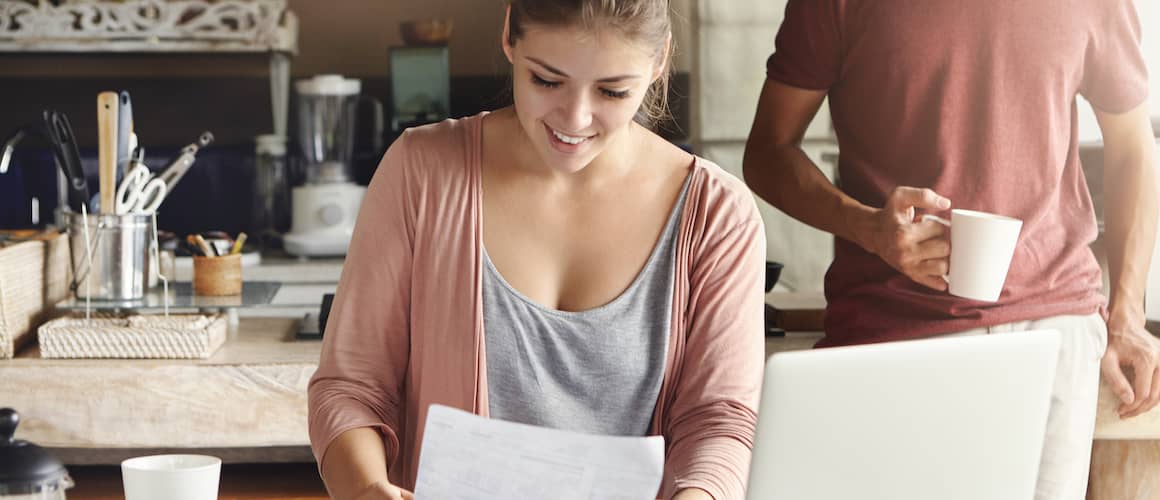 Woman reviewing pay stubs and finances, illustrating a woman examining pay stubs and financial documents, likely related to mortgage or financial planning.