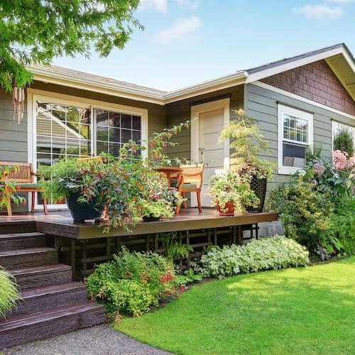 A cozy house with a charming garden and a lovely deck, perfect for relaxation and outdoor gatherings.