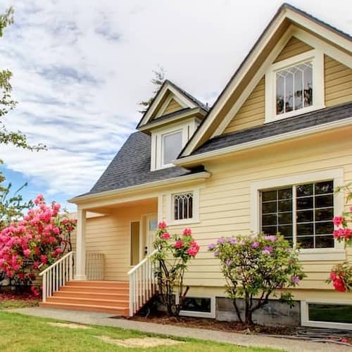 Yellow house exterior with white trim and green lawn.