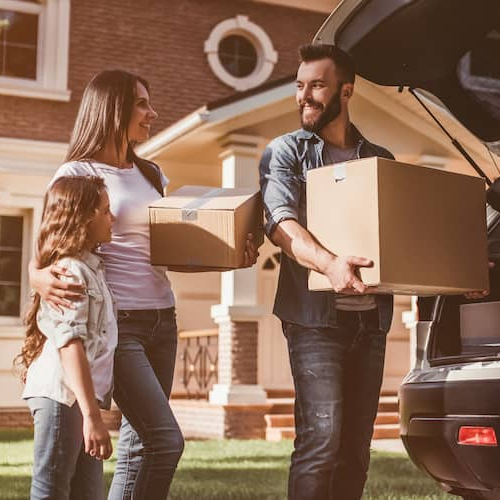 A family packing a car to move, indicating a relocation or moving process.