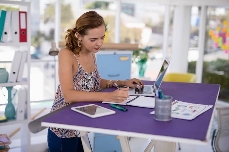 RHB Assets From IGX: Woman working in a home office with a purple standing desk