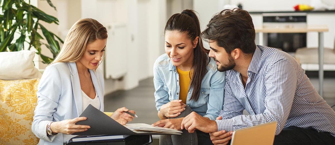 A couple discussing real estate investment or mortgage with an agent.