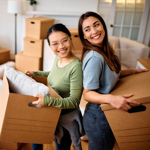 Two young women moving into a new home together.