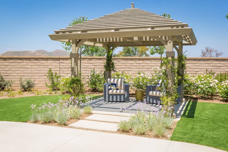 RHB Assets From IGX: An inviting patio area featuring a wooden pergola and comfortable seating.