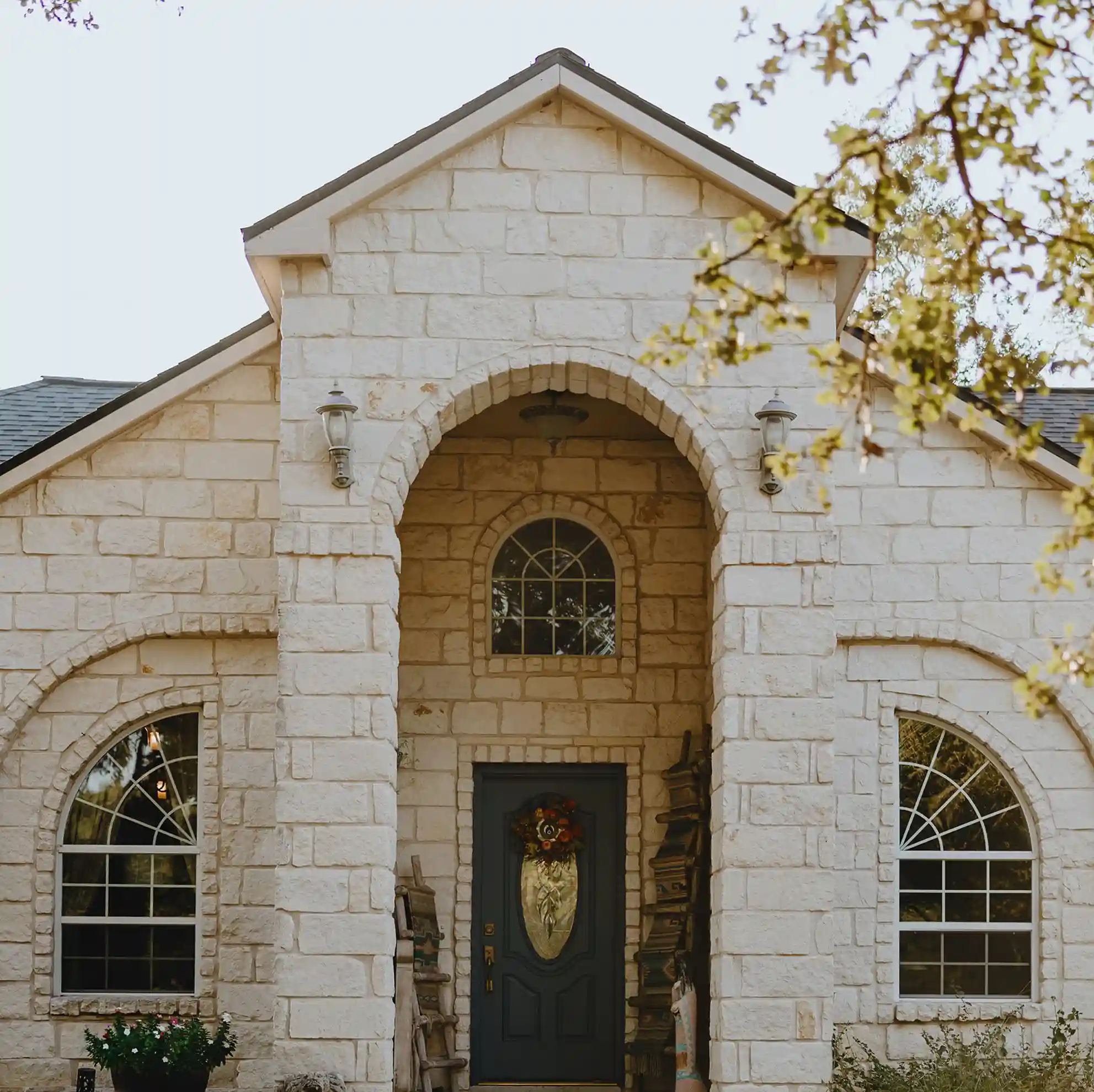 A large white brick house with trees framing the front.