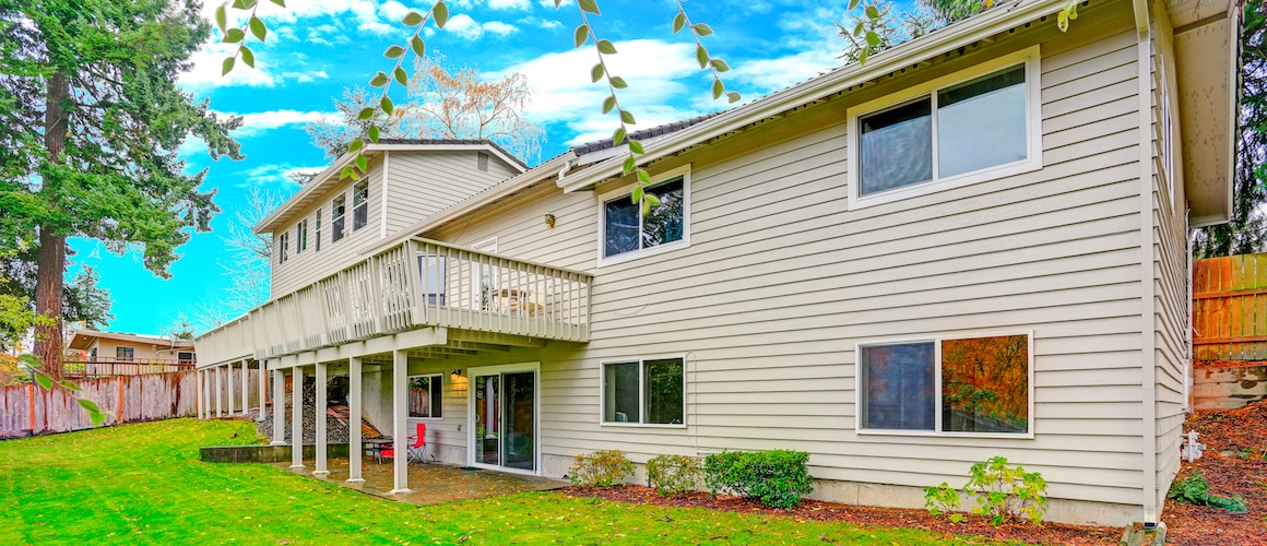 A house featuring a large porch in a suburban setting.