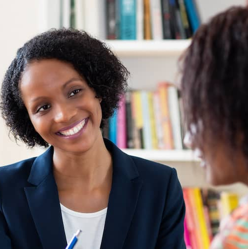 An African American woman signing a contract, potentially related to real estate or homeownership.