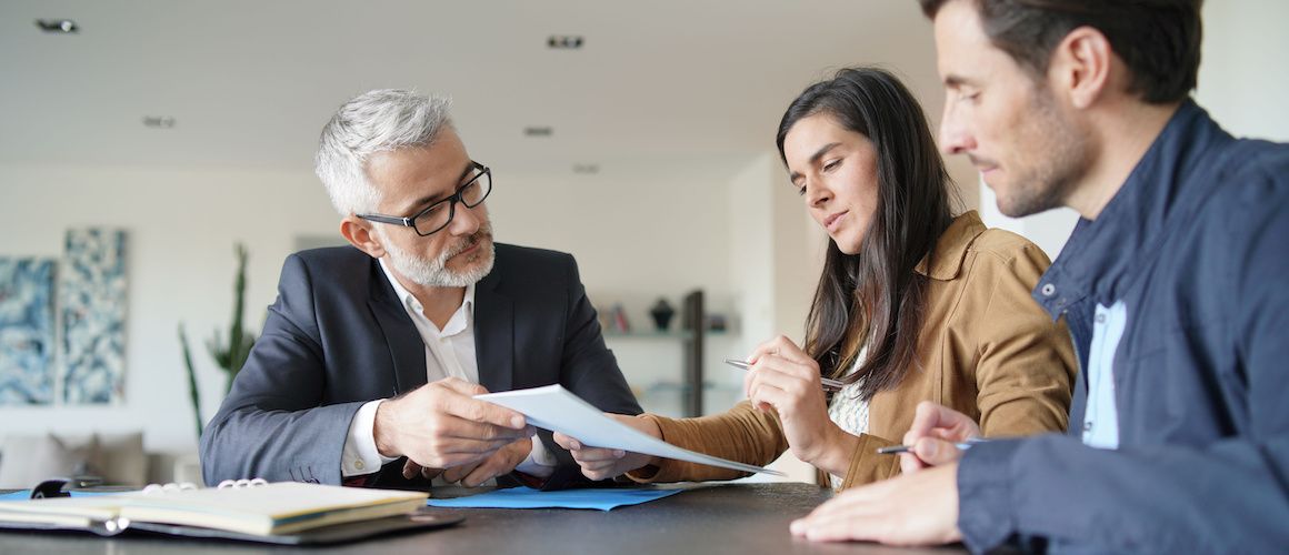 RHB Assets From IGX: Couple signing real estate documents with an agent