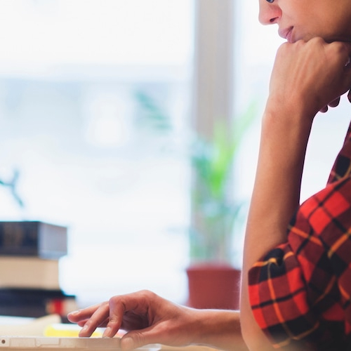 Woman working on a computer, possibly managing real estate details or financial matters.