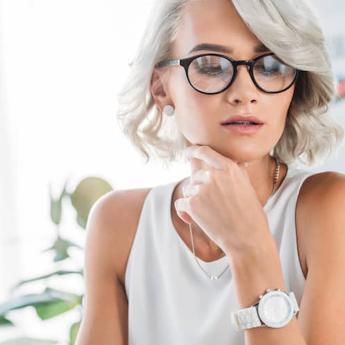 Woman with glasses working at desk.