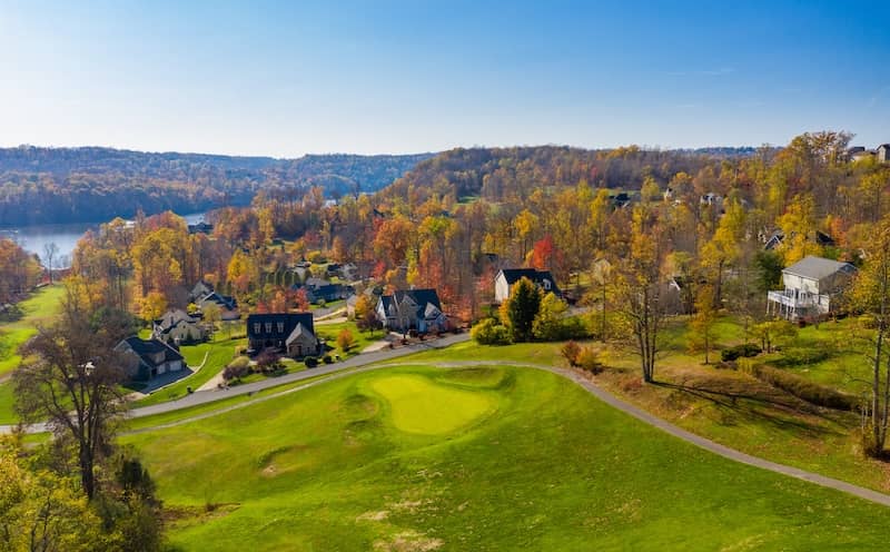 Aerial photo of a golf course and quaint neighborhood during fall.