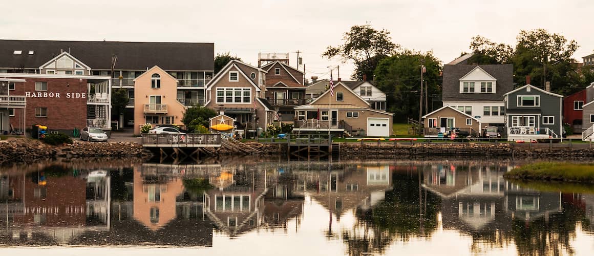 An image displaying a row of houses along the Maine coast, showcasing coastal properties.
