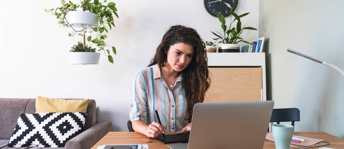 Image of woman reviewing loan payments on computer.